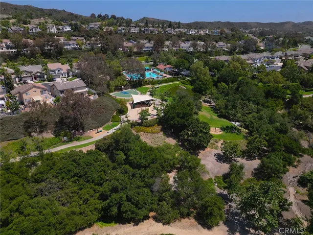 an aerial view of residential house with outdoor space and trees all around