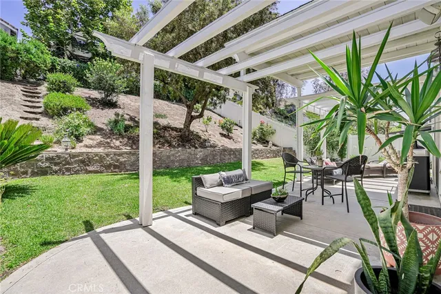 a view of a patio with a table and chairs and a large tree
