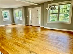 a view of an empty room with window and a kitchen