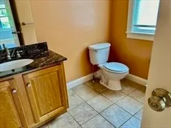 a bathroom with a granite countertop toilet and sink