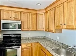 a kitchen with stainless steel appliances granite countertop a stove a sink and a microwave