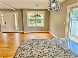 a view of empty room with window and chandelier