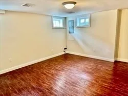 an empty room with wooden floor and a window