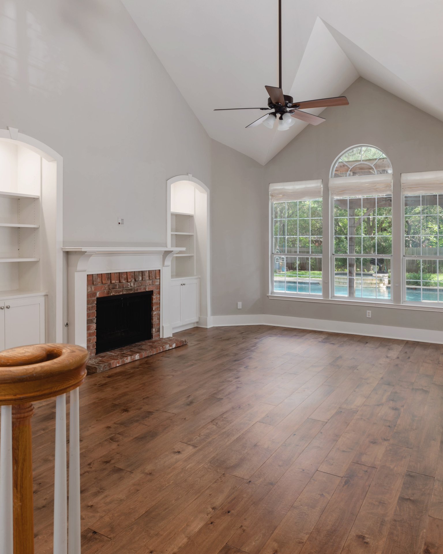 5512 Ballenton Lane Austin, TX 78739 - Photo 8 of 40 A spacious living room features vaulted ceilings, rich hardwood floors, and a brick fireplace flanked by custom built-ins.