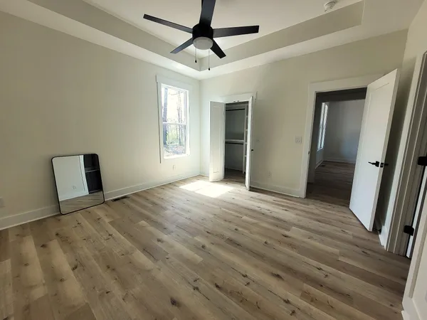a view of a livingroom with wooden floor and a ceiling fan