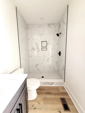 a bathroom with a sink a toilet and shower