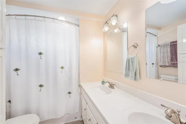 a bathroom with a sink vanity mirror and toilet