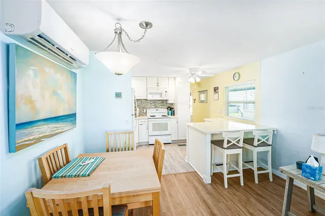 a kitchen with stainless steel appliances granite countertop a dining table chairs and granite counter tops