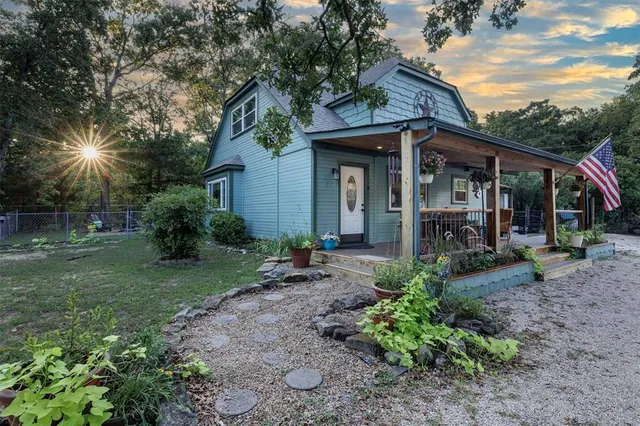 a view of a chair and table in backyard of the house