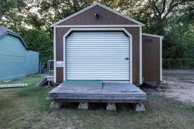 a view of a wooden house with a big yard and large tree