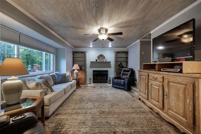 a living room with furniture a flat screen tv and a fireplace