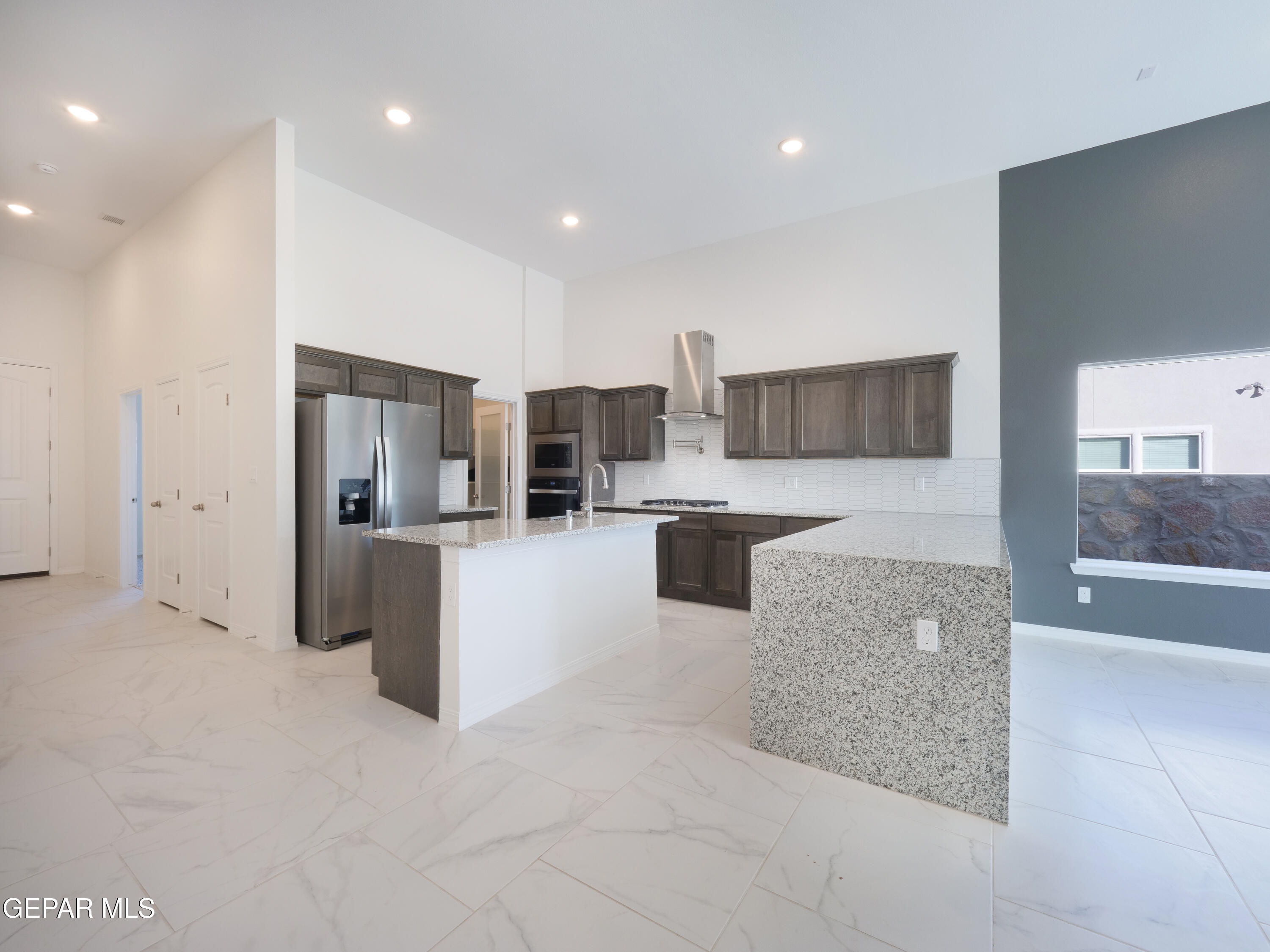 6041 Summer Ridge Santa Teresa, NM 88008 - Photo 4 of 13 a large room with stainless steel appliances kitchen island granite countertop a refrigerator and a sink