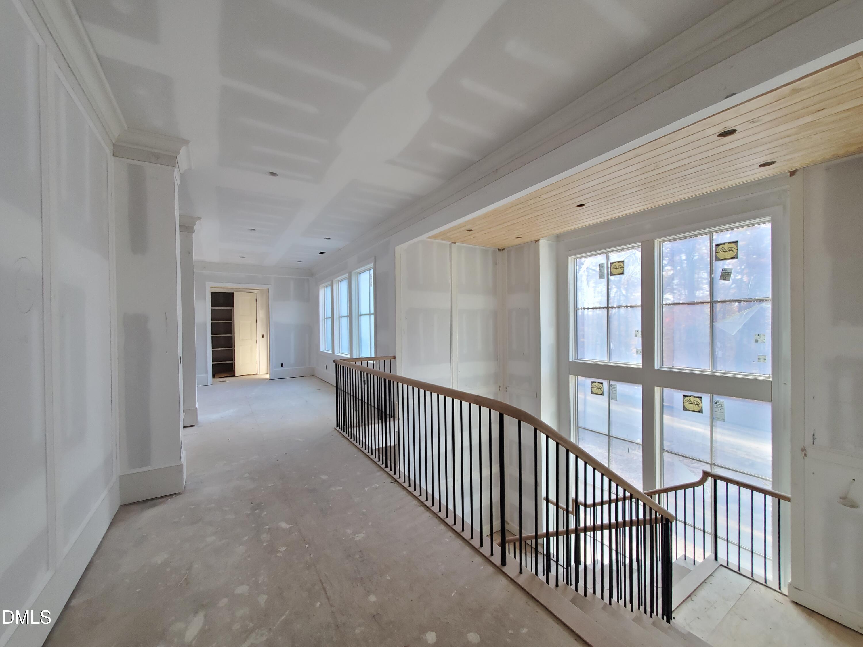 6508 Sanctuary Falls Drive Raleigh, NC 27614 - Photo 16 of 41 a view of a hallway with wooden floor and windows