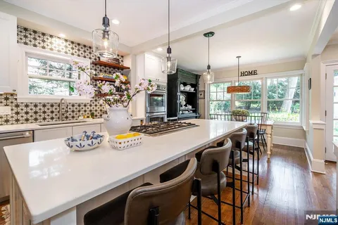 a kitchen with kitchen island granite countertop a table and chairs in it