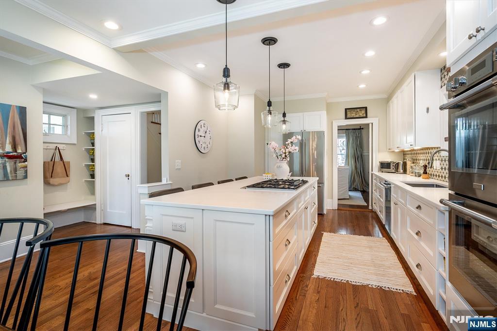 111 Montclair Avenue Montclair, NJ 07042 - Photo 15 of 46 a kitchen with stainless steel appliances kitchen island granite countertop a stove a sink a refrigerator and white cabinets with wooden floor