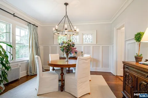 a dining room with furniture a chandelier and wooden floor