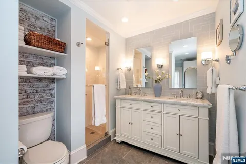 a bathroom with a granite countertop toilet sink and a mirror