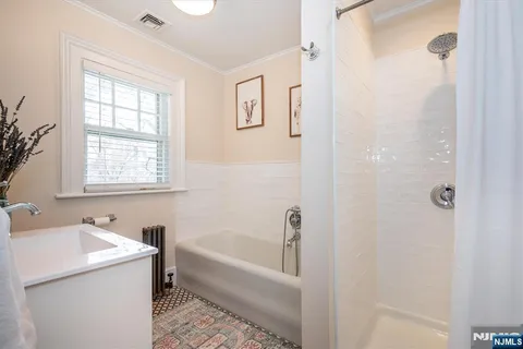a bathroom with a tub sink and mirror
