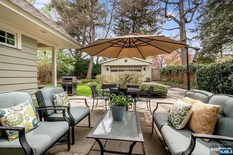 a view of a patio with couches and chairs under an umbrella