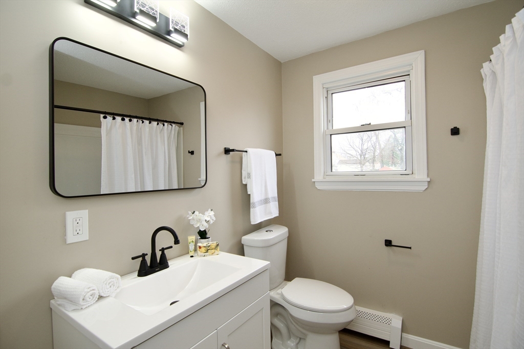 1295 Bay Street Springfield, MA 01109 - Photo 28 of 42 a bathroom with a toilet sink and mirror