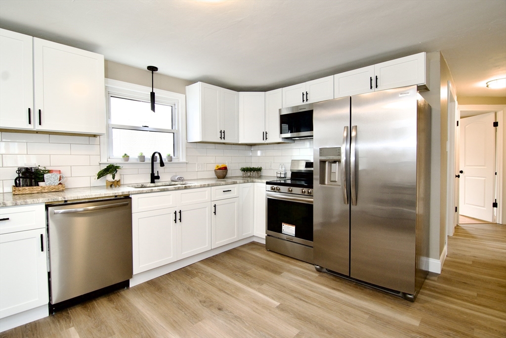1295 Bay Street Springfield, MA 01109 - Photo 9 of 42 a kitchen with cabinets stainless steel appliances and wooden floor