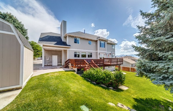 1273 Grayson Court Sandy, UT 84094 - Photo 26 of 27 Rear exterior featuring a multi-level wood deck, light-toned siding, and a prominent chimney