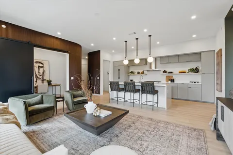 a living room with furniture and a view of kitchen