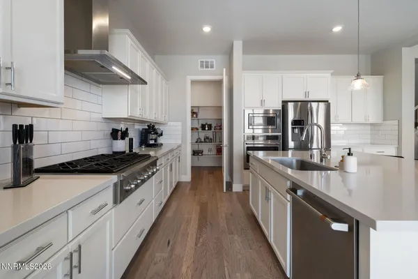 a large kitchen with stainless steel appliances granite countertop a stove a sink and a refrigerator