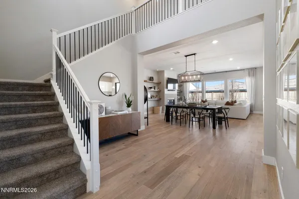 a view of entryway and dining room with wooden floor