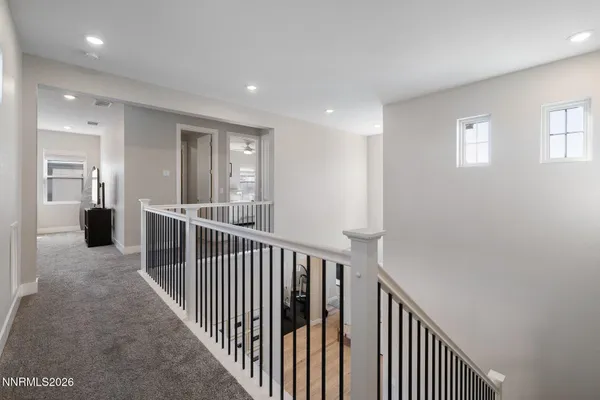 a view of a hallway with wooden floor and windows