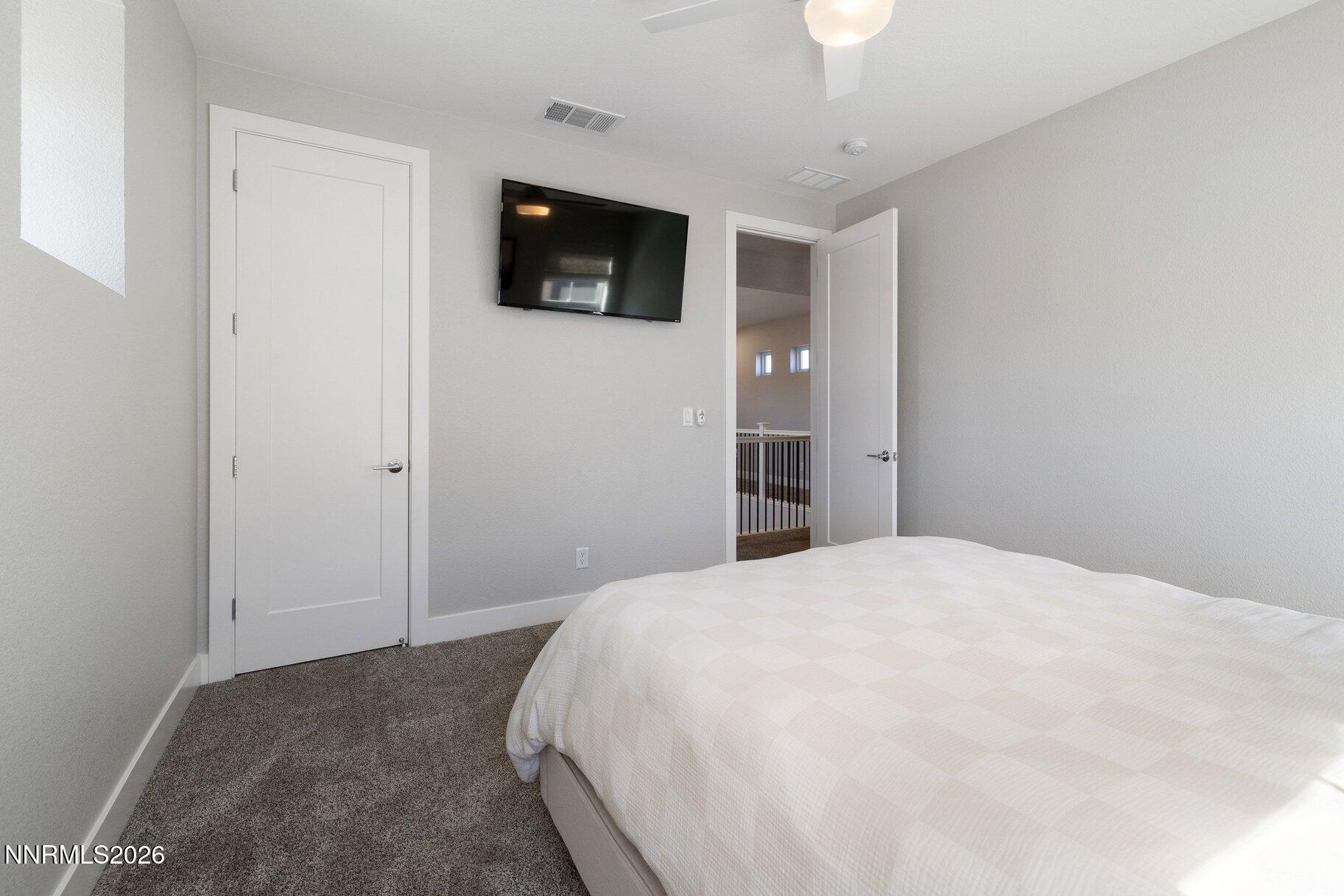 911 Solarium Drive Reno, NV 89511 - Photo 29 of 37 a bedroom with a bed and a flat screen tv