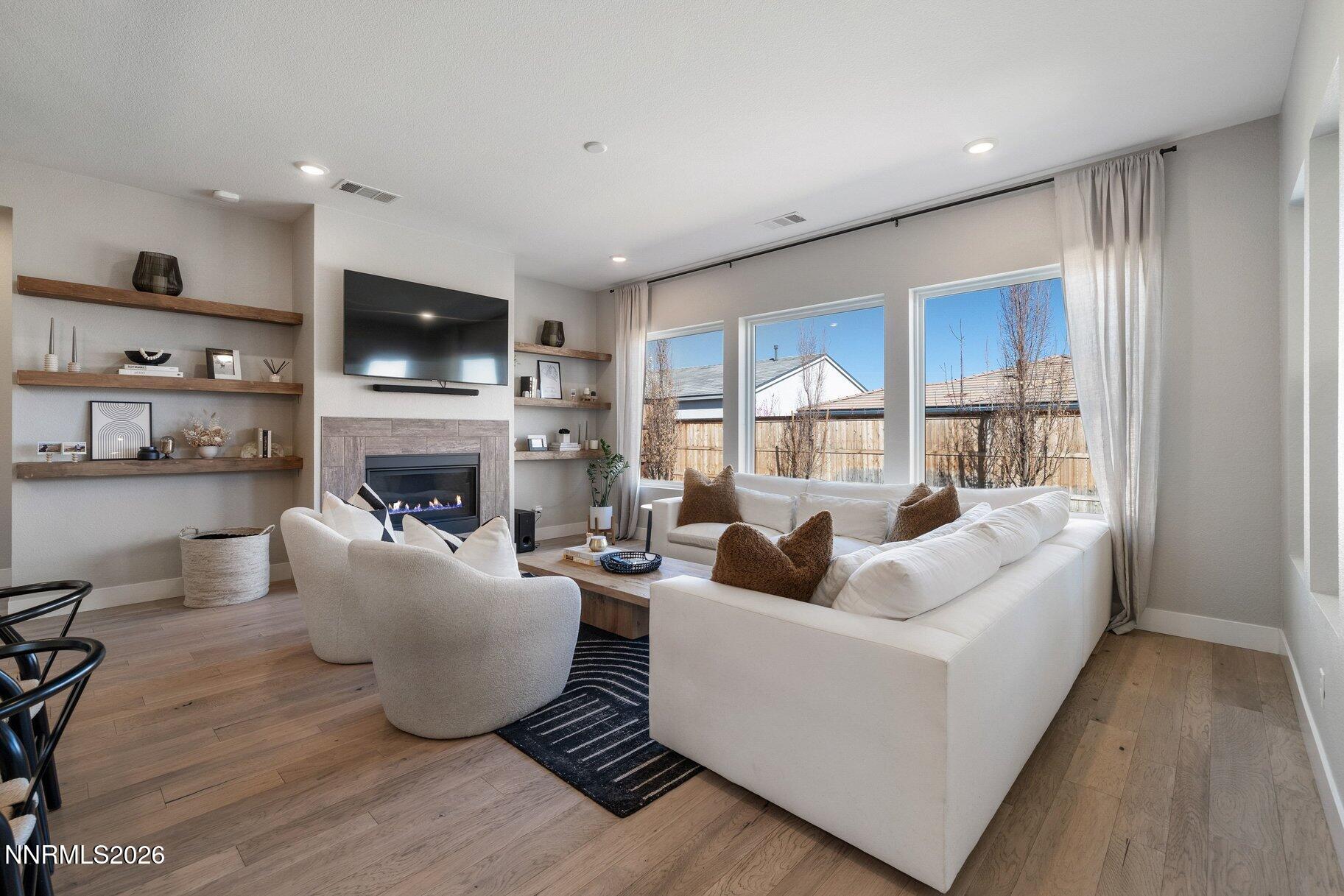 911 Solarium Drive Reno, NV 89511 - Photo 6 of 37 a living room with furniture a fireplace and a flat screen tv