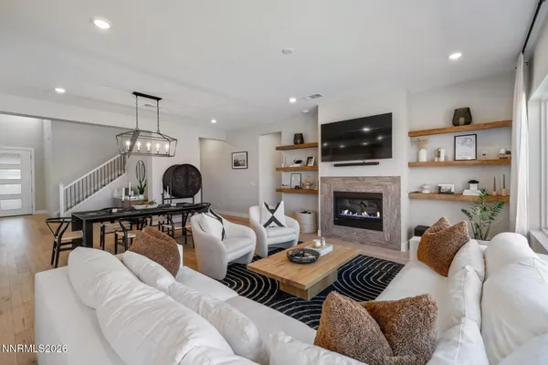 a living room with furniture a flat screen tv and a fireplace