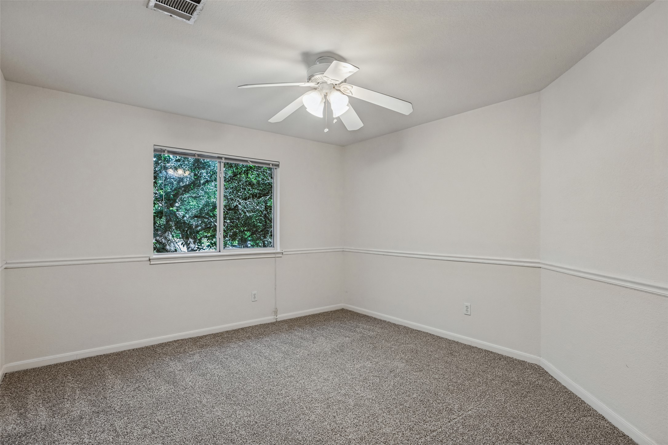 2832 Grimes Ranch Road Austin, TX 78732 - Photo 17 of 23 Soft carpeting pairs with classic chair rail molding in this comfortable bedroom space.