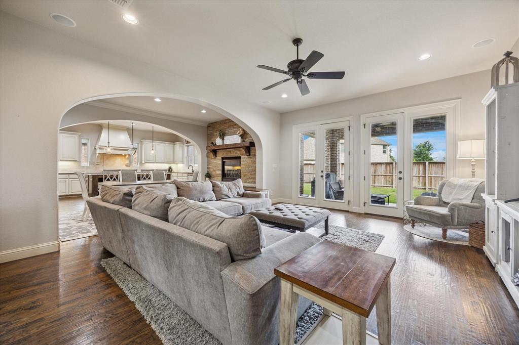 580 Butchart Drive Prosper, TX 75078 - Photo 2 of 40 Living area with arched walkways, a ceiling fan, baseboards, dark wood finished floors, and recessed lighting