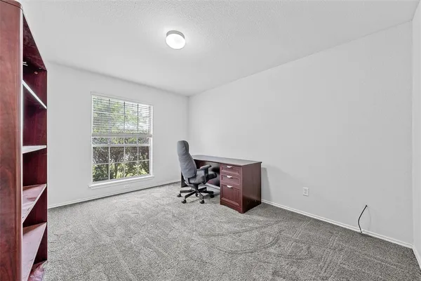 a view of a workspace with furniture and a window