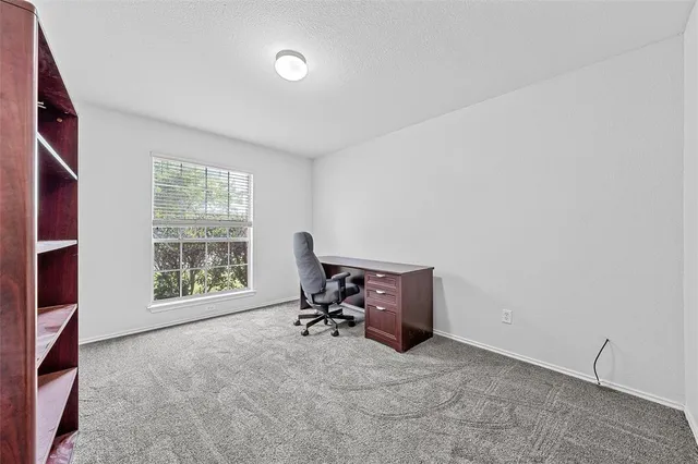 a view of a workspace with furniture and a window