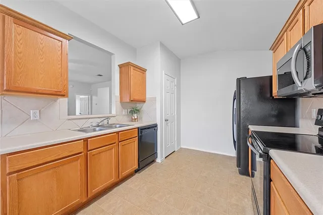 a kitchen with granite countertop a sink stove and refrigerator