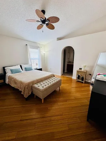 a bedroom with a bed and a ceiling fan