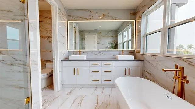 a spacious bathroom with a granite countertop sink mirror and bathtub