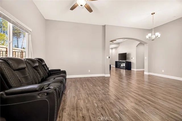 a view of a livingroom with a fireplace a chandelier and wooden floor