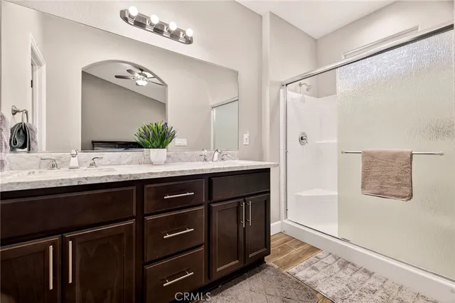 a bathroom with a granite countertop shower sink and mirror