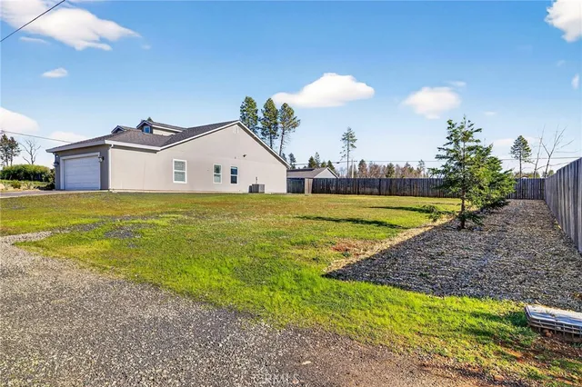 a view of a house with a yard and a large tree