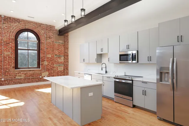 a kitchen with stainless steel appliances granite countertop a sink a stove a refrigerator cabinets and living room view