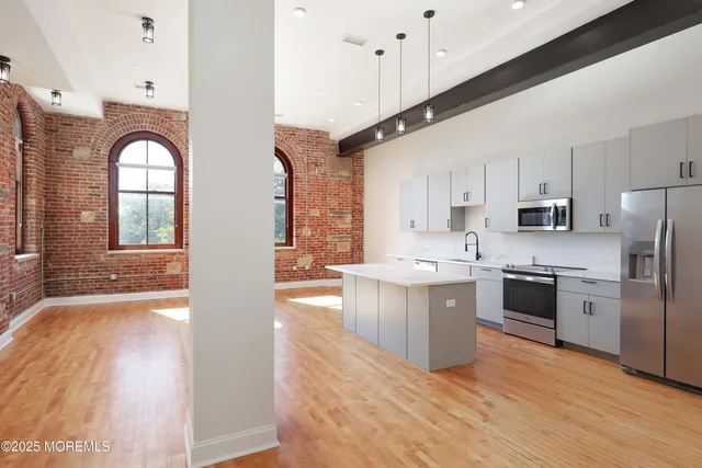 a large white kitchen with stainless steel appliances and white cabinets