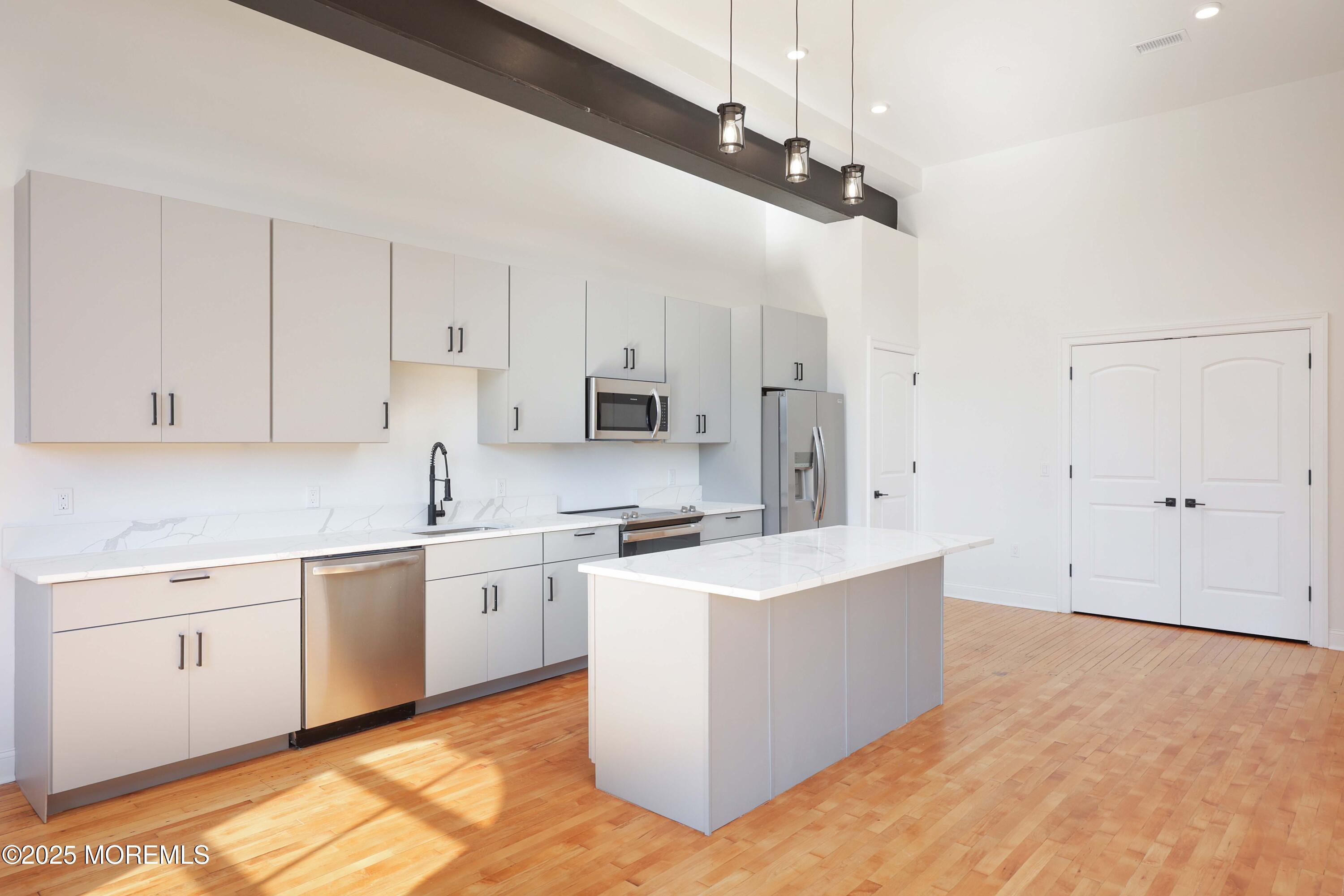 179 Chelsea Avenue, Unit 210 Long Branch, NJ 07740 - Photo 8 of 22 a large white kitchen with stainless steel appliances and white cabinets