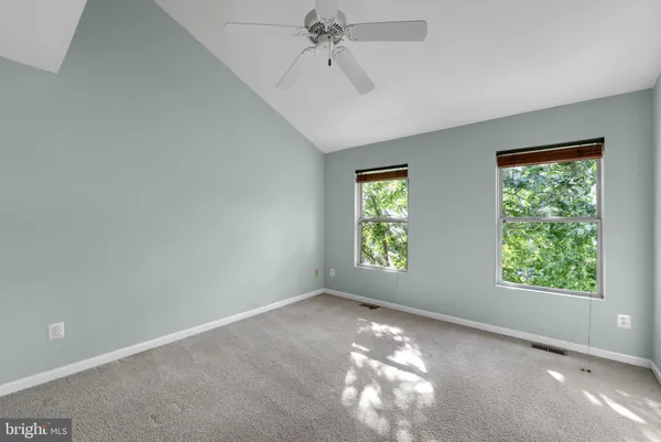 an empty room with a window and a ceiling fan