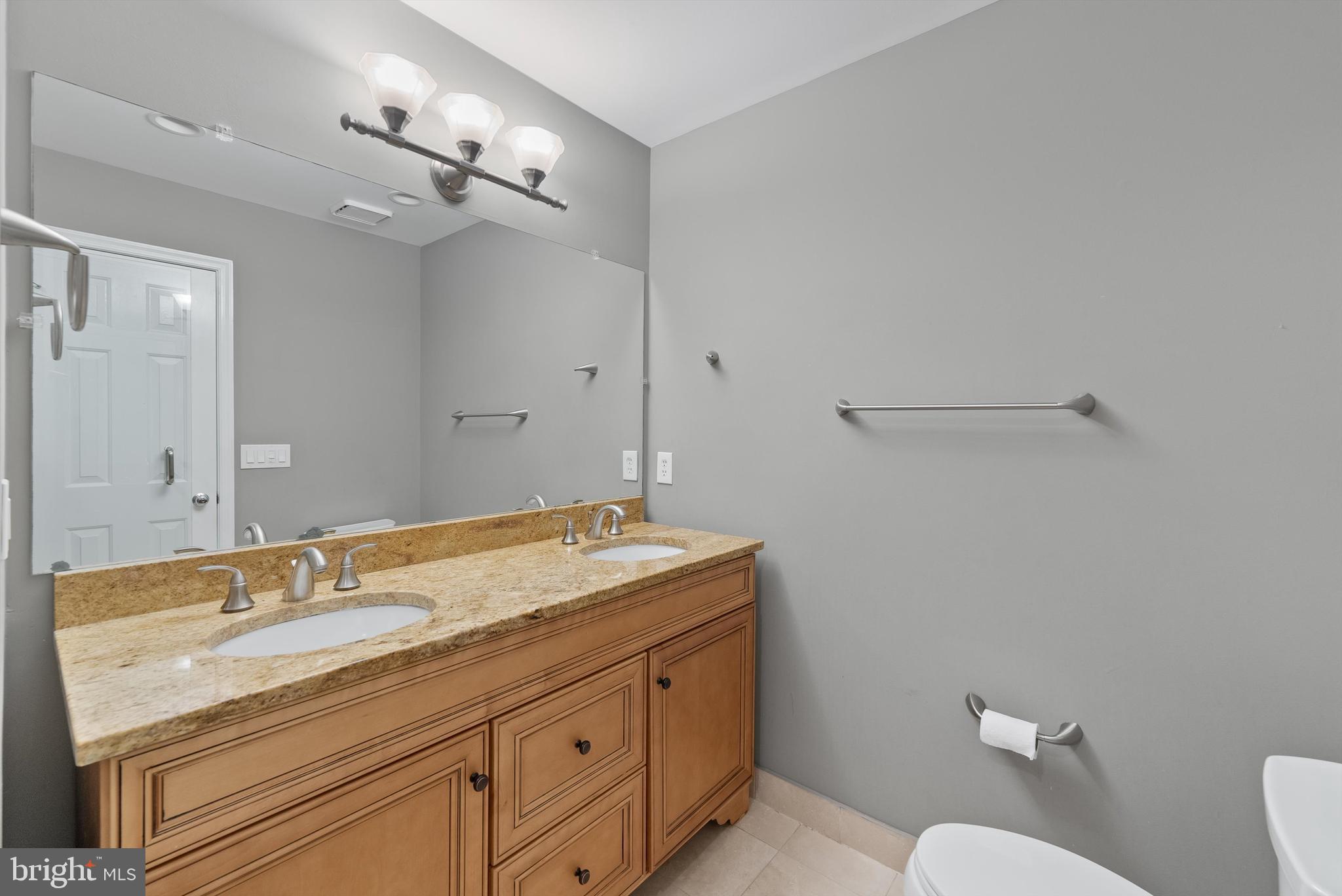 12081 Edgemere Circle Reston, VA 20190 - Photo 19 of 36 a bathroom with a granite countertop sink a toilet and a mirror