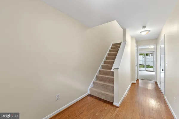 a view of a hallway with wooden floor and stairs