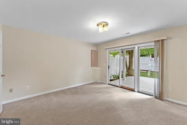 an empty room with sliding glass door and windows